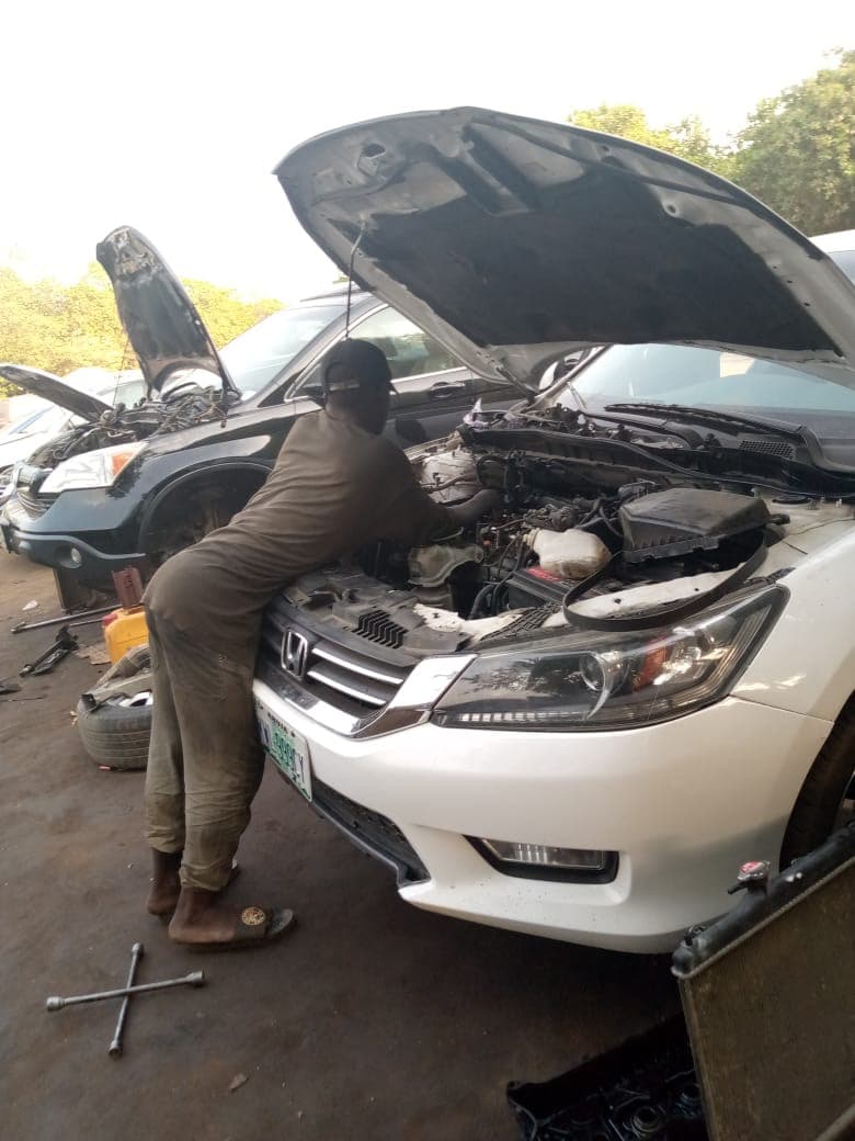 An auto mechanic working on a car engine