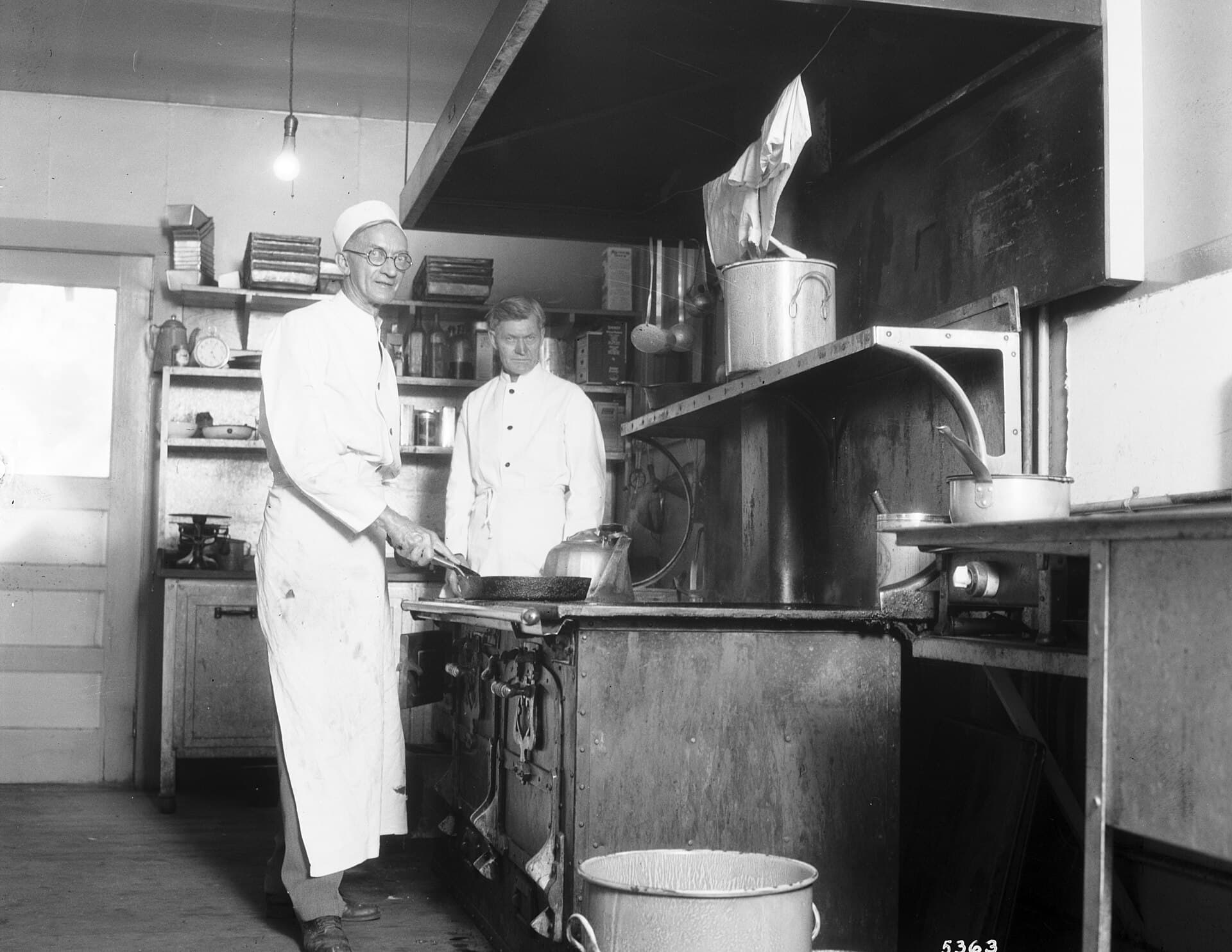 Two cooks working in a commercial kitchen in 1930